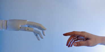 A human hand reaching out to a robotic one, symbolizing the innovation of technology and personalization